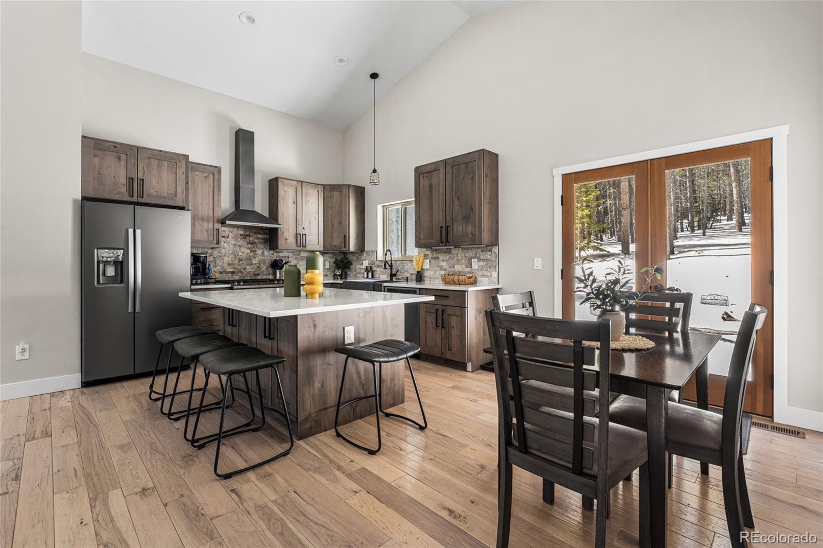 79 Beaver Road Idaho Springs, CO 80452 - Photo 13 of 50 a kitchen with stainless steel appliances a dining table chairs refrigerator and cabinets