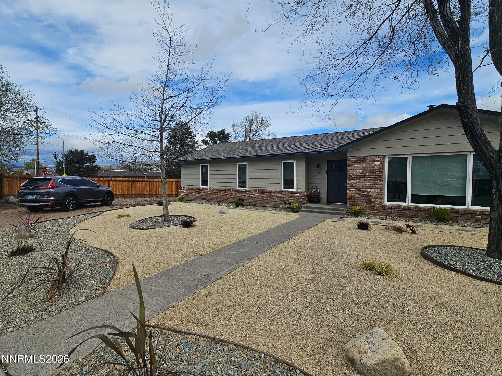 a front view of a house with cars parked on road