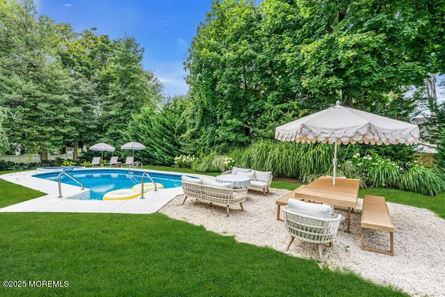 a view of a swimming pool with a table and chairs under an umbrella