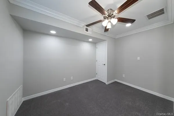 an empty room with ceiling fan and window