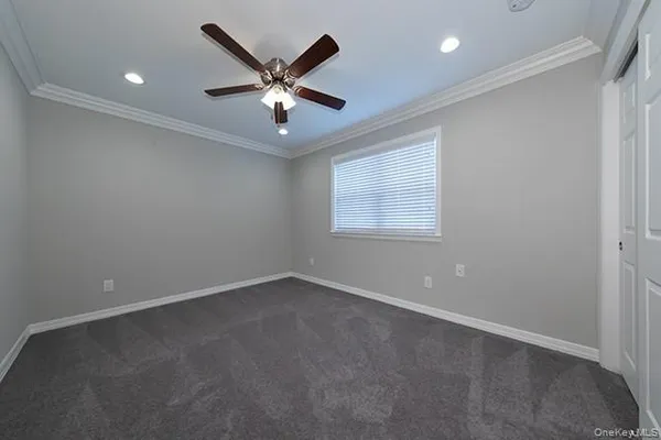 an empty room with a window and a fan