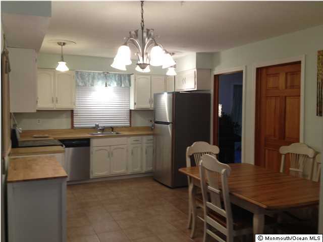 795 Hulses Corner Road Howell, NJ 07731 - Photo 5 of 22 a kitchen with stainless steel appliances granite countertop a refrigerator a stove a sink dishwasher a dining table and chairs with wooden floor