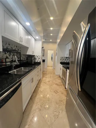 a large kitchen with stainless steel appliances lots of counter space and a sink
