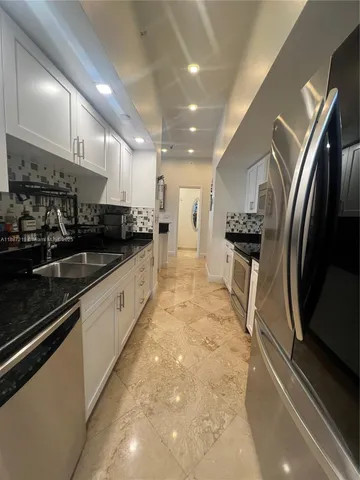 a large kitchen with stainless steel appliances lots of counter space and a sink