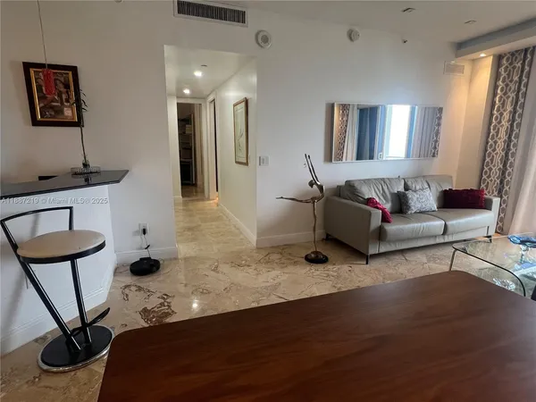 a living room with furniture a window and a potted plant