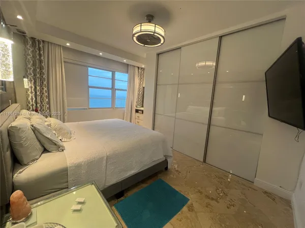 a bedroom with a bed and a flat screen tv