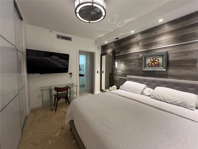 a bedroom with a bed and a flat screen tv