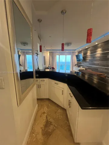 a large white kitchen with a sink a refrigerator and window