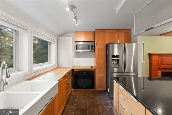 a kitchen with granite countertop a refrigerator and a sink