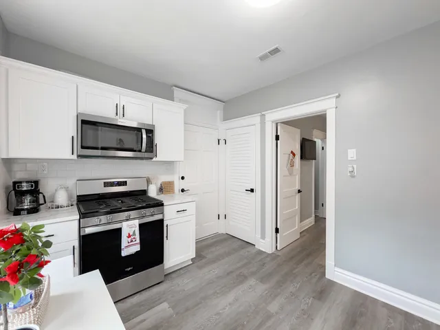 a kitchen with granite countertop a refrigerator and a wooden floor