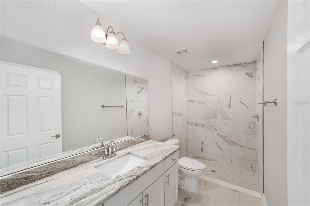 8767 North Quarry Way Dunnellon, FL 34434 - Photo 11 of 18 a bathroom with a granite countertop sink a toilet and shower