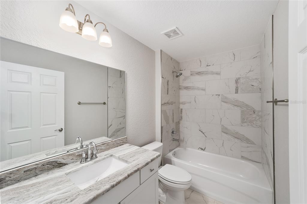 8767 North Quarry Way Dunnellon, FL 34434 - Photo 15 of 18 a bathroom with a granite countertop sink a toilet and bathtub