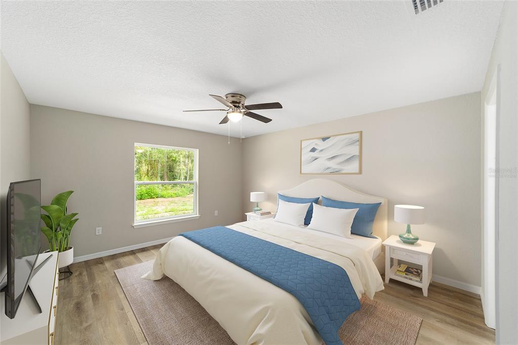 8767 North Quarry Way Dunnellon, FL 34434 - Photo 4 of 18 a bedroom with a large bed and a chandelier