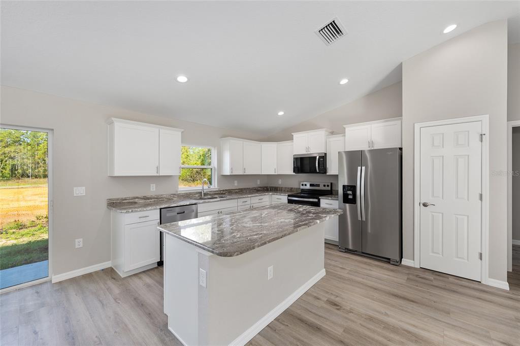 8767 North Quarry Way Dunnellon, FL 34434 - Photo 7 of 18 a kitchen with stainless steel appliances granite countertop a stove a sink and a refrigerator