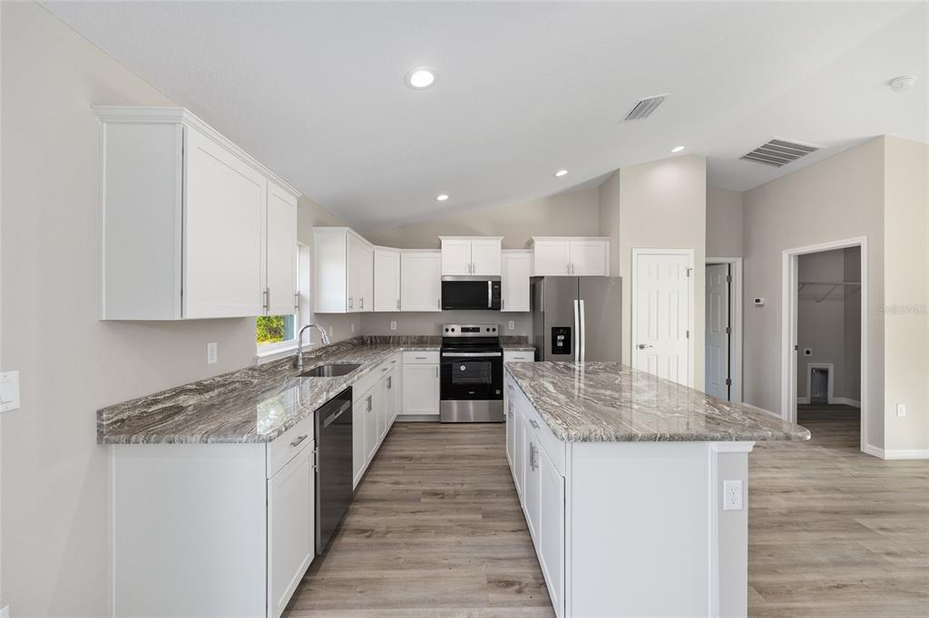 8767 North Quarry Way Dunnellon, FL 34434 - Photo 8 of 18 a large kitchen with granite countertop a large counter top stainless steel appliances and cabinets