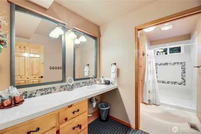 a bathroom with a tub a sink and a mirror