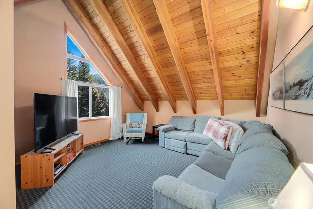 a living room with furniture a flat screen tv and a floor to ceiling window