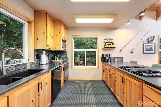a kitchen with stainless steel appliances a stove a sink and a white cabinets