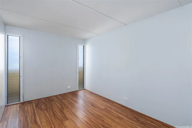a view of an empty room with wooden floor