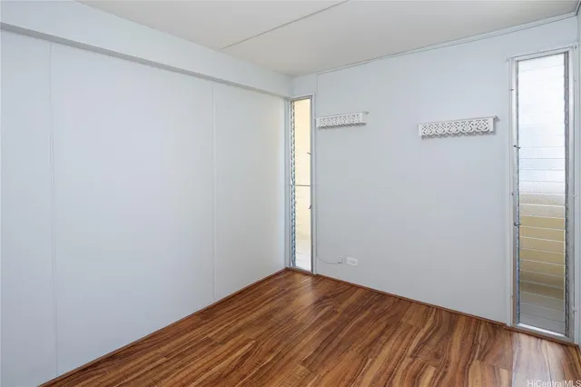 a view of an empty room with wooden floor