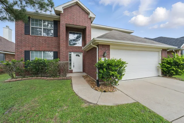 a front view of a house with a yard and potted plants