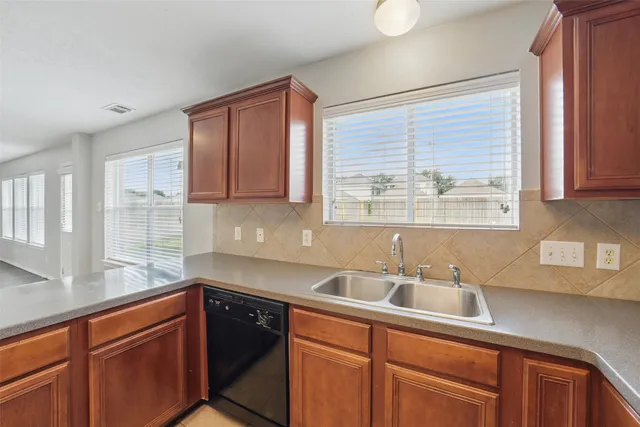 a kitchen with stainless steel appliances wooden cabinets a sink and a window