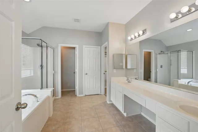 a spacious bathroom with a tub a double vanity sink and mirror