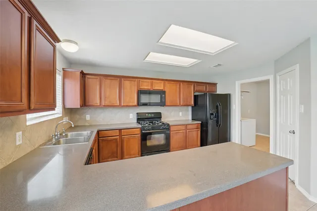 a kitchen with stainless steel appliances granite countertop a refrigerator sink and stove