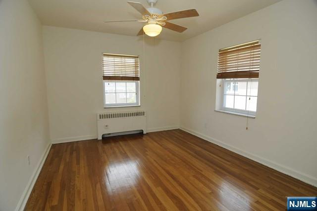 5 Heights Road, Unit G1 Ridgewood, NJ 07450 - Photo 4 of 7 an empty room with wooden floor windows and fan