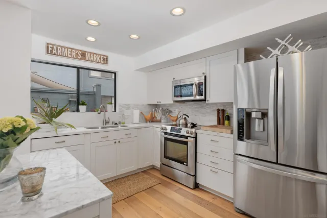 a kitchen with white cabinets and stainless steel appliances