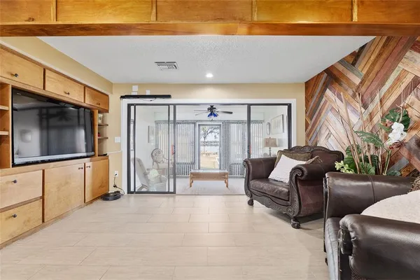 a living room with furniture a flat screen tv and a large window