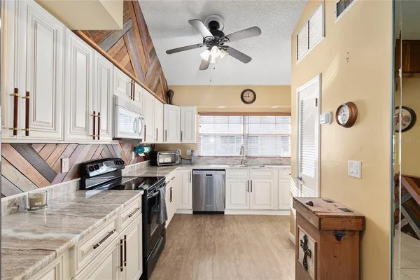 a kitchen with a stove a sink a refrigerator and a microwave