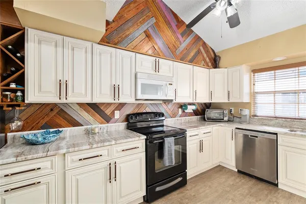 a kitchen with white cabinets and white appliances