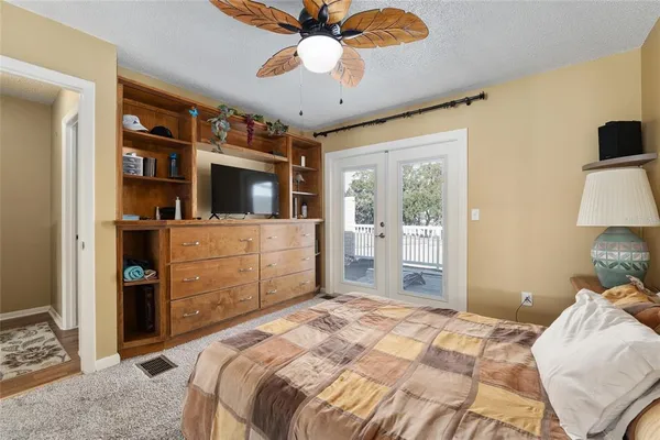 a bedroom with a bed and a flat tv screen on dresser