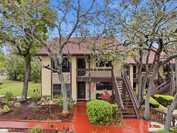 a front view of a house with a tree