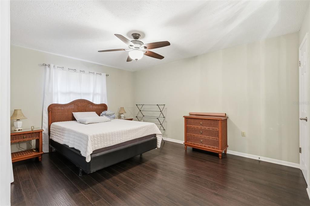 7650 Forest Trail, Unit 6 Port Richey, FL 34668 - Photo 19 of 37 a bedroom with a bed and a chandelier
