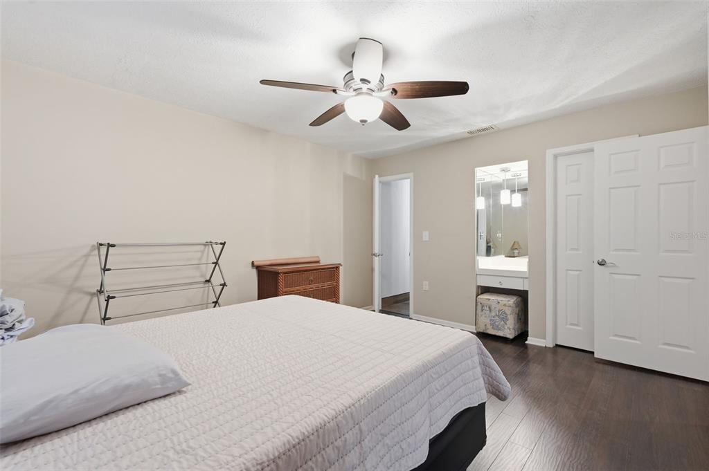 7650 Forest Trail, Unit 6 Port Richey, FL 34668 - Photo 21 of 37 a bedroom with a bed and a chandelier