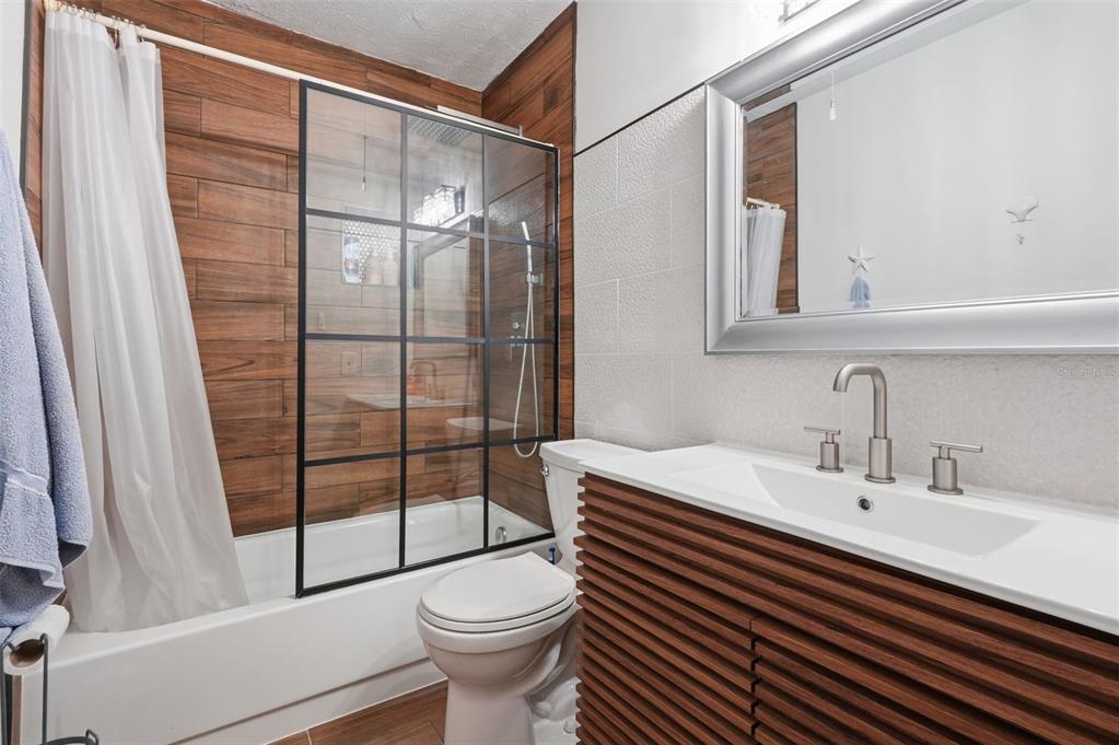 7650 Forest Trail, Unit 6 Port Richey, FL 34668 - Photo 22 of 37 a bathroom with a sink a toilet a mirror and shower
