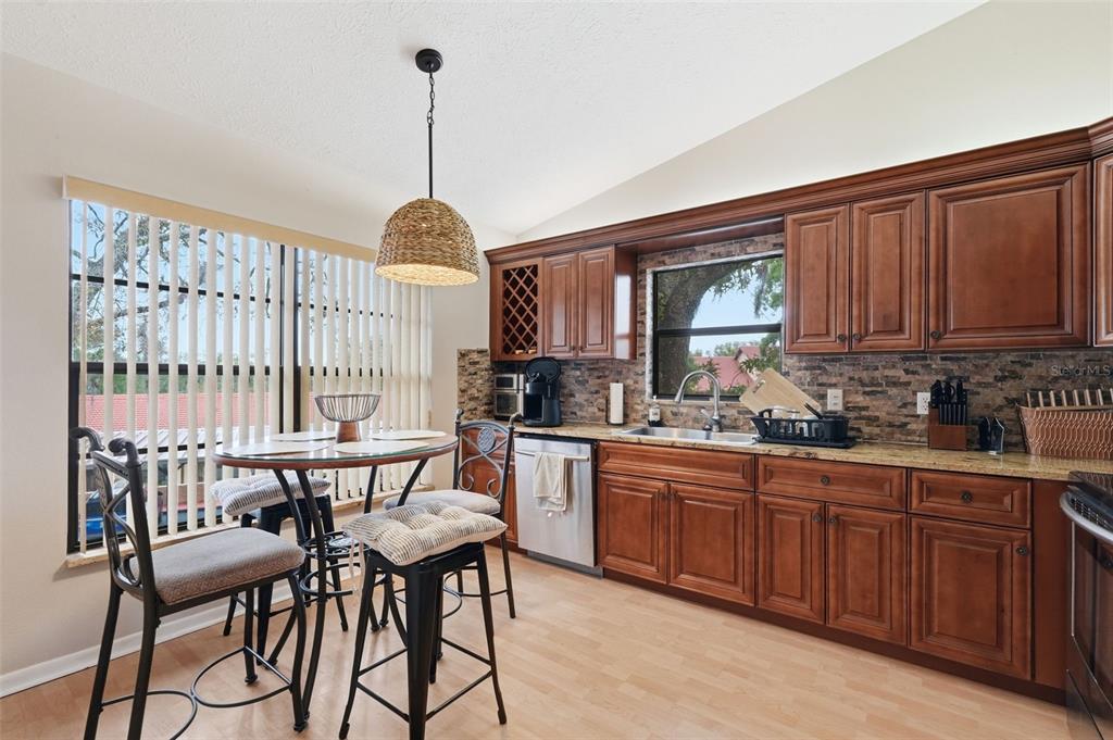 7650 Forest Trail, Unit 6 Port Richey, FL 34668 - Photo 7 of 37 a kitchen with stainless steel appliances granite countertop a stove a sink dishwasher and cabinets with wooden floor