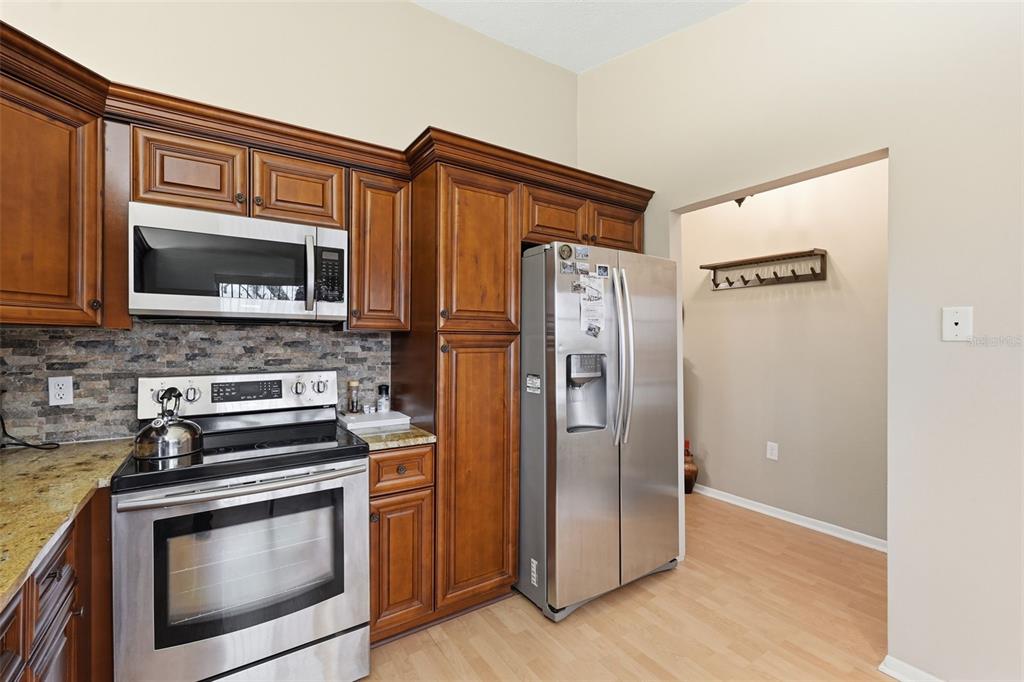 7650 Forest Trail, Unit 6 Port Richey, FL 34668 - Photo 8 of 37 a kitchen with stainless steel appliances granite countertop a refrigerator stove and microwave