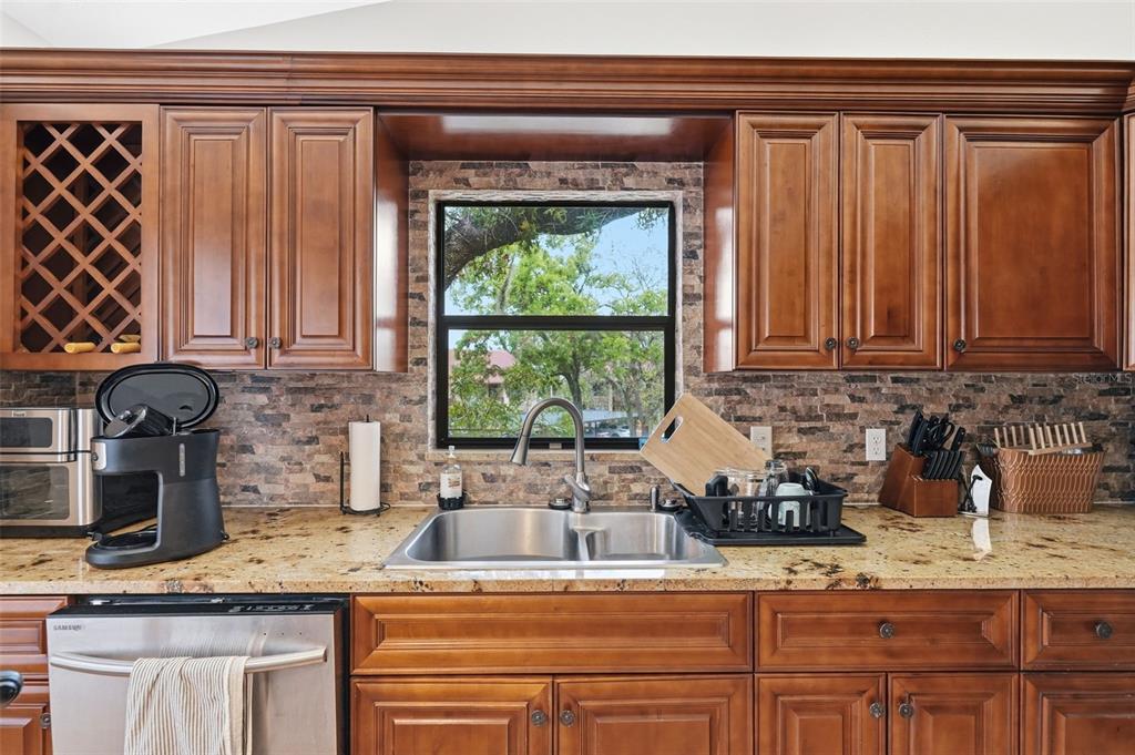 7650 Forest Trail, Unit 6 Port Richey, FL 34668 - Photo 9 of 37 a kitchen with granite countertop a sink a stove and cabinets