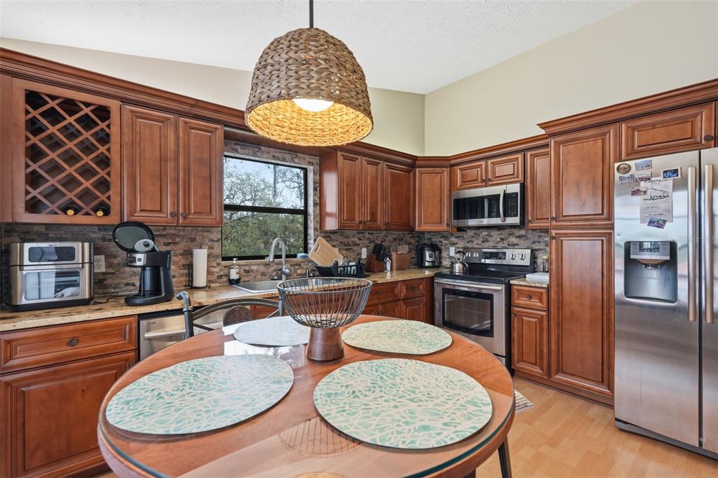 7650 Forest Trail, Unit 6 Port Richey, FL 34668 - Photo 10 of 37 a kitchen with stainless steel appliances granite countertop a stove a sink and a refrigerator