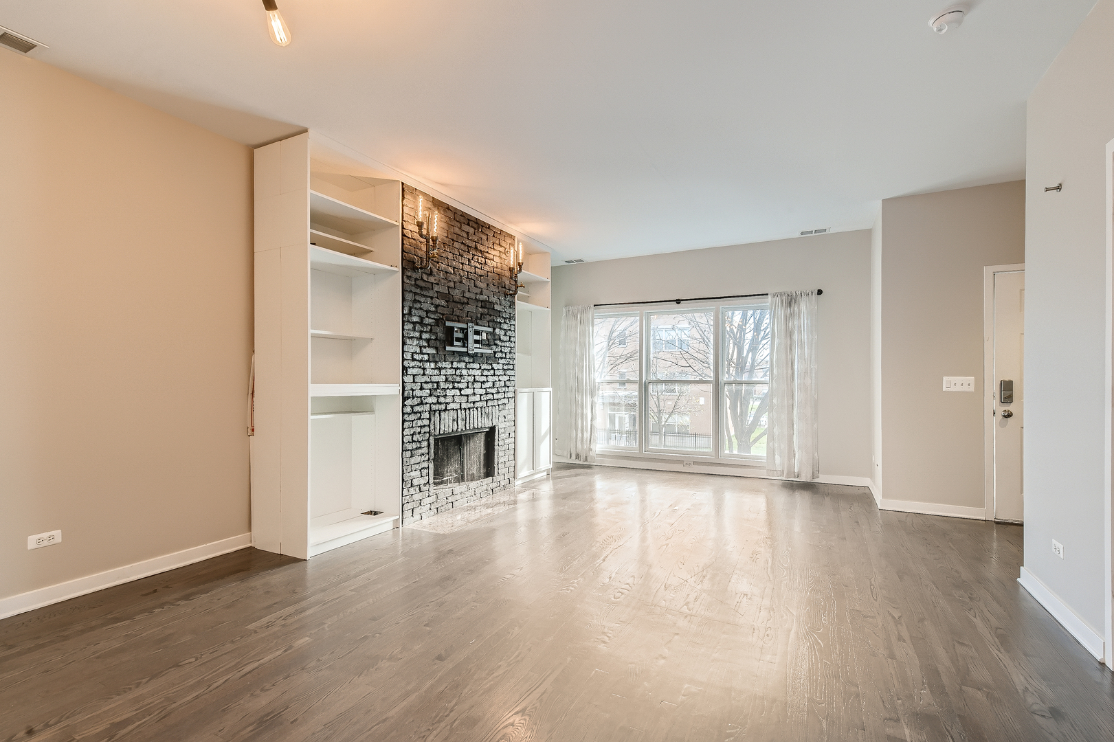 1318 West Grenshaw Street, Unit B Chicago, IL 60607 - Photo 4 of 16 a view of an empty room with wooden floor and a window