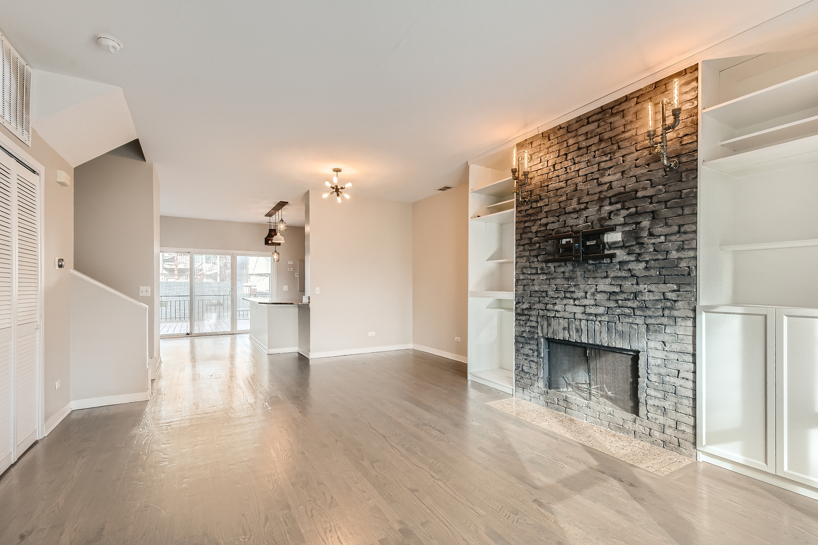1318 West Grenshaw Street, Unit B Chicago, IL 60607 - Photo 5 of 16 a view of empty room with wooden floor and fireplace