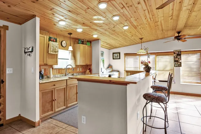 a kitchen with stainless steel appliances kitchen island granite countertop a table chairs in it and wooden floors