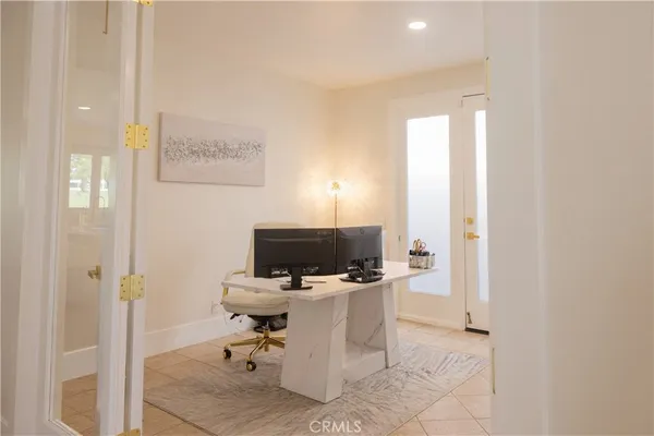 a view of a workspace with furniture and a window