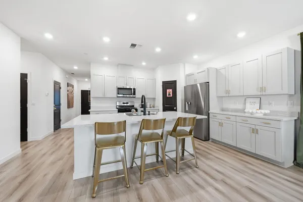 a kitchen with kitchen island granite countertop a sink and refrigerator
