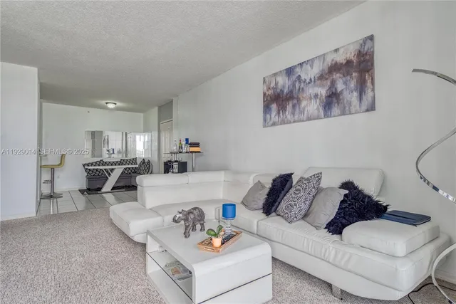 a living room with furniture and kitchen view