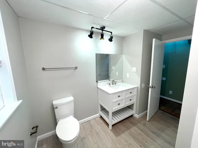 a bathroom with a granite countertop sink toilet a mirror and shower