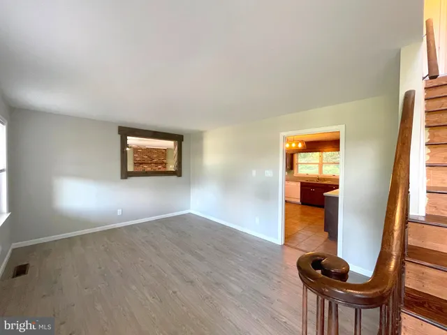 a view of empty room with a window and wooden floor